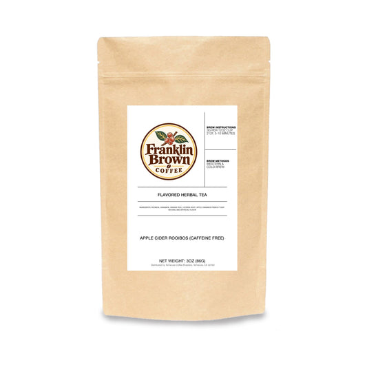 A cup of Apple Cider next to Rooibos Tea leaves, showcasing healthy and flavorful beverage options